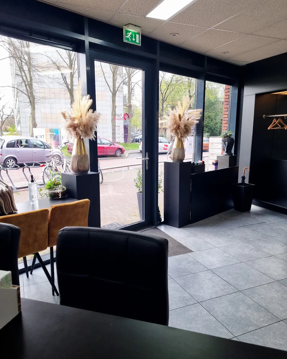 Pampas in een geribbelde gouden vaas bij het raam van de salon