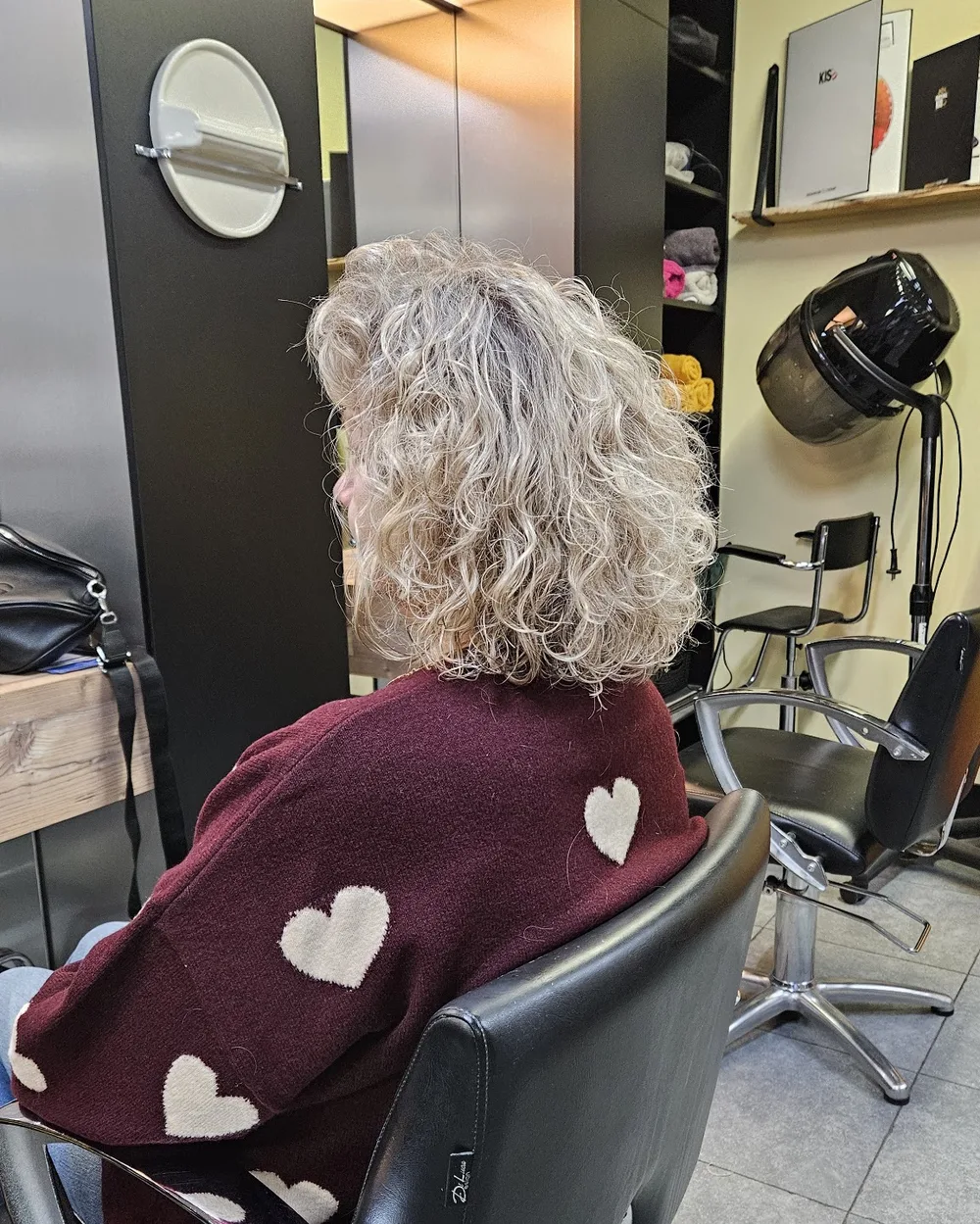 Grijsblonde krullen, van achteren gezien in de salonstoel